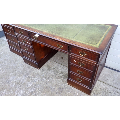 670 - A reproduction oak pedestal desk, 138cm wide with matching filing cabinet (2)
