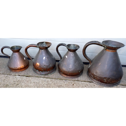718 - Four copper measure jugs, largest 36cm tall