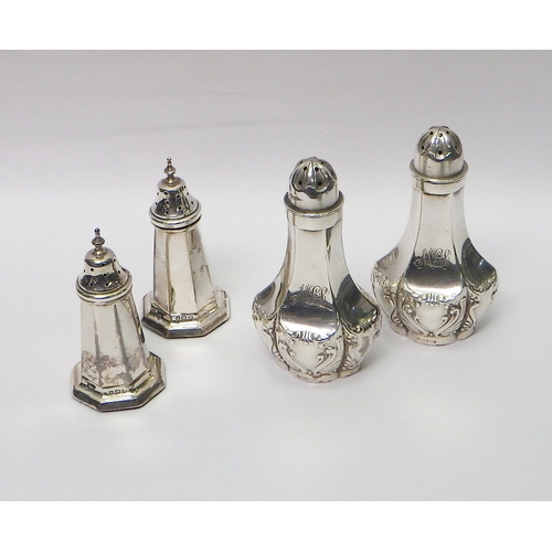 6 - Silver condiments: a pair of repousse pepper pots; a pair of octagonal pepper pots having loaded bas... 