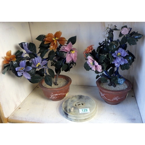 129 - An Oriental carved and polished stone base together with a pair of Oriental glass bonsai trees in te... 