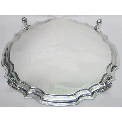 22 - A silver presentation salver standing on four scroll feet, Sheffield 1946.  305mm diameter / 840g
