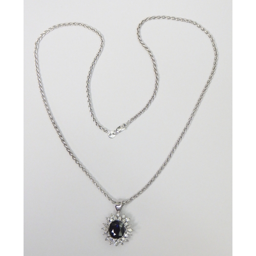 31 - A cluster pendant comprising an oval sapphire surrounded by 28 diamonds of round an marquise cuts, u... 