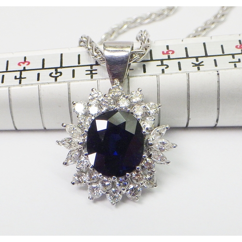 31 - A cluster pendant comprising an oval sapphire surrounded by 28 diamonds of round an marquise cuts, u... 