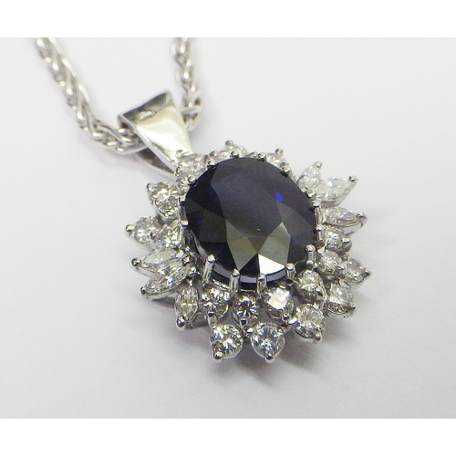 31 - A cluster pendant comprising an oval sapphire surrounded by 28 diamonds of round an marquise cuts, u... 