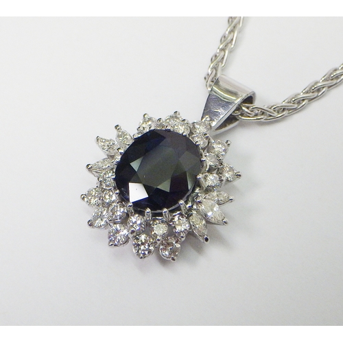 31 - A cluster pendant comprising an oval sapphire surrounded by 28 diamonds of round an marquise cuts, u... 
