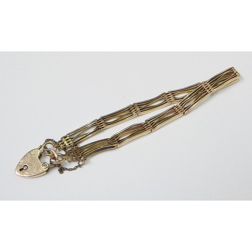 35A - A slim fancy gate link bracelet, unmarked yellow metal, the padlock clasp marked 15c.   The bracelet... 