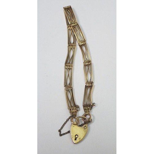 35A - A slim fancy gate link bracelet, unmarked yellow metal, the padlock clasp marked 15c.   The bracelet... 
