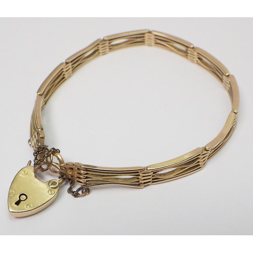 35A - A slim fancy gate link bracelet, unmarked yellow metal, the padlock clasp marked 15c.   The bracelet... 