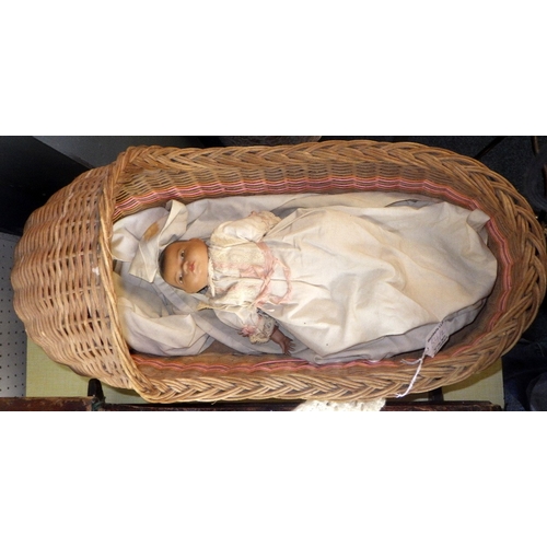 54 - An Armand Marseille doll in a pine crib together with a 20thC bisque doll in a wicker crib (2)