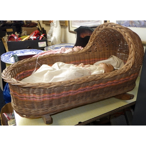 54 - An Armand Marseille doll in a pine crib together with a 20thC bisque doll in a wicker crib (2)