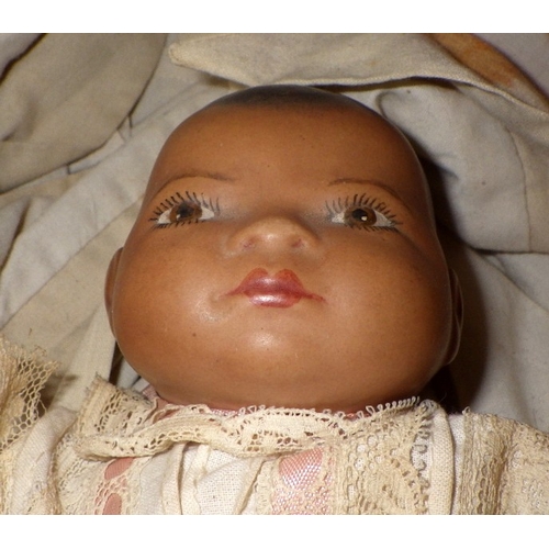 54 - An Armand Marseille doll in a pine crib together with a 20thC bisque doll in a wicker crib (2)