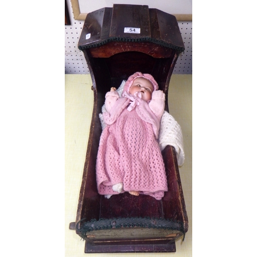 54 - An Armand Marseille doll in a pine crib together with a 20thC bisque doll in a wicker crib (2)