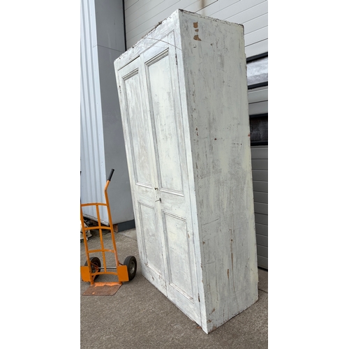 726 - A large Victorian painted pine two door cupboard, 234cm tall, 127cm wide (wheels not included)