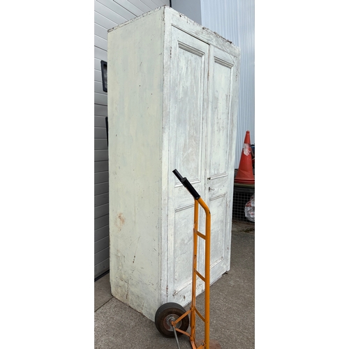 726 - A large Victorian painted pine two door cupboard, 234cm tall, 127cm wide (wheels not included)
