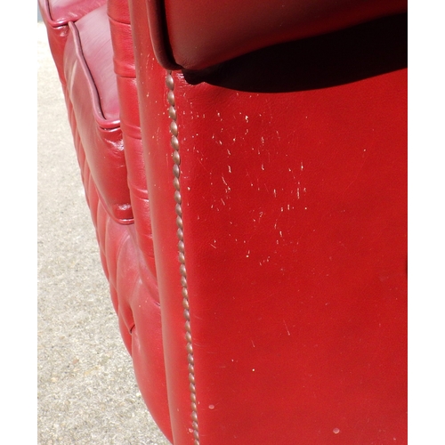 613 - A red button upholstered leather two seater Chesterfield sofa, cat scratches, 148cm wide
