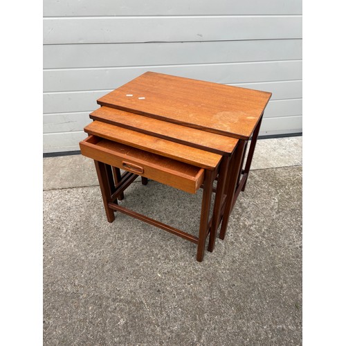 707 - A teak nest of three occasional tables, with drawer,  together with an ottoman (2)