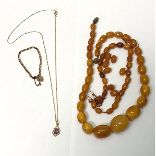 A 9ct gold and synthetic amethyst pendant, the whole suspended on a yellow metal chain; a baby's bracelet, unmarked yellow metal fastening on an indistinctly marked yellow metal padlock clasp; a necklace of graduated amber beads of marbled clear and butterscotch colour, a group of similar loose beads.  Necklace 415mm long as strung / central bead 24 x 18mm.