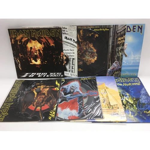 339 - A collection in two bags of Iron Maiden LPs and singles including shaped picture discs.