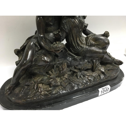 1040 - A heavy bronze figural group bronze of a boy and girl seated upon rocks. 30 x 38cm.