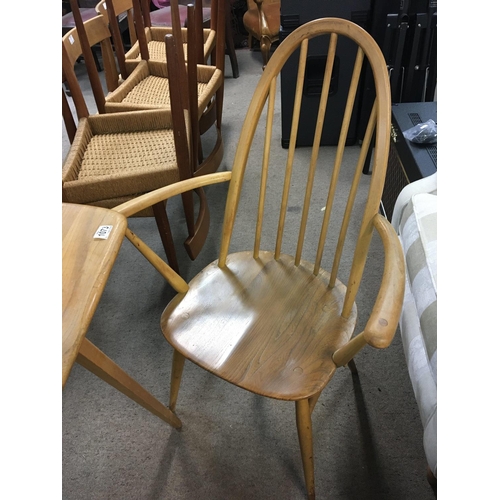 1358 - A blonde Ercol elm and beechwood kitchen table of rectangular shape and two matching open arm chairs... 