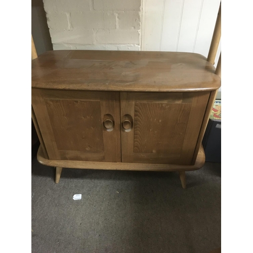 1364 - A Ercol open bookcase with three open selfs and cupboards under on turned legs height 190 cm .