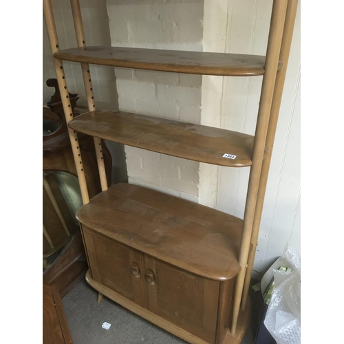 1364 - A Ercol open bookcase with three open selfs and cupboards under on turned legs height 190 cm .