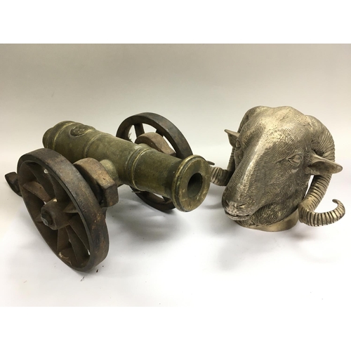 1839 - A silver plated rams head together with a brass and cast iron model cannon.