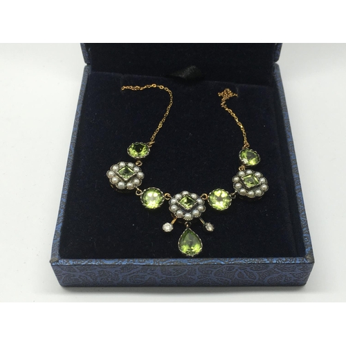 702 - A boxed necklace set with peridots, seed pearls and diamonds.