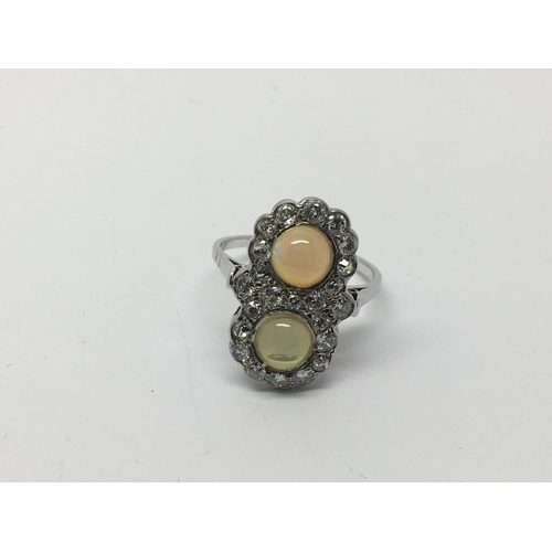 704 - An unusual 18ct white gold Victorian ring set with two cabuchon opals and several old cut diamonds, ... 