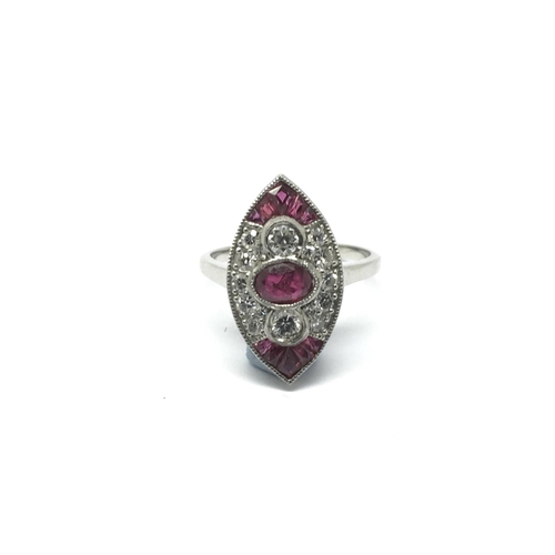 705 - A platinum marquise shaped panel ring set with oval cut and calibre cut rubies and RBC diamonds, app... 