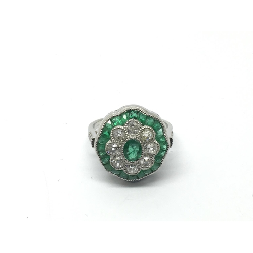 707 - A platinum, emerald and diamond daisy style ring set with old cut diamonds, approx 0.95ct and emeral... 