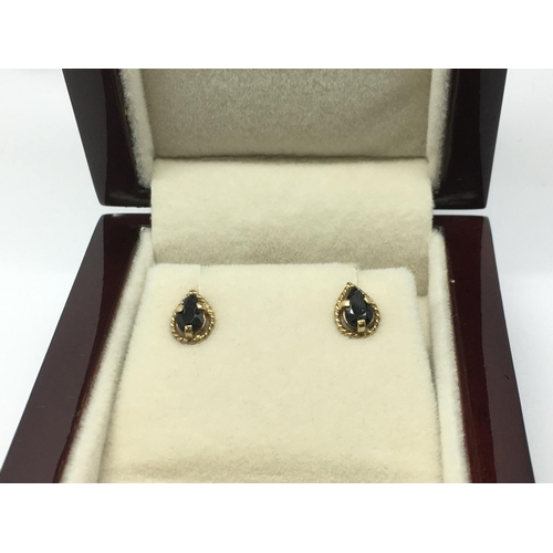 724 - A pair of 9ct gold and sapphire earrings.