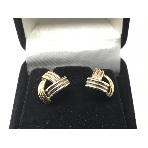 725 - A pair of 9ct three colour gold earrings.