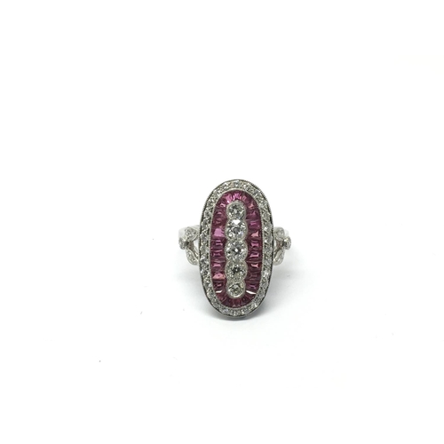 763 - A platinum, ruby and diamond ring set with five vertical diamonds, surrounded by calibre cut rubies ... 