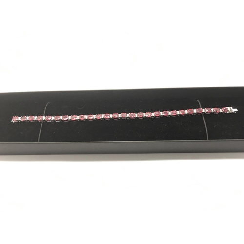 767 - An 18ct white gold, ruby and diamond line bracelet set with oval cut rubies, approx 13.14t, diamonds... 