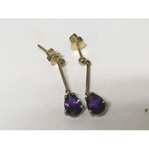 772 - A pair of gold earrings with drop pear shaped amethyst.