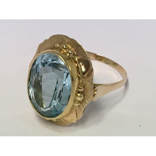 774 - A fancy gold and large blue topaz set ring (unmarked). 7.2g.