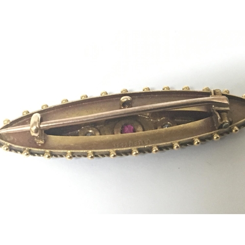 777 - A vintage 15carat gold brooch set with ruby flanked by two diamonds. Weight 4g