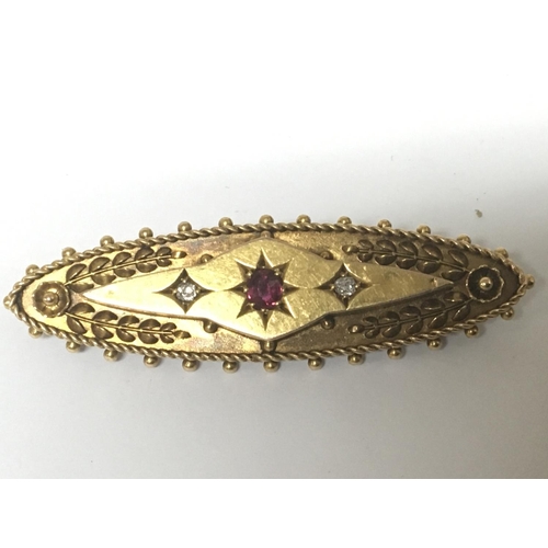 777 - A vintage 15carat gold brooch set with ruby flanked by two diamonds. Weight 4g