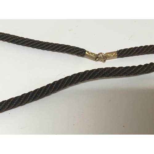 778 - A late Victorian unmarked gold seal attached to a woven hair cord with gold clip and bar.