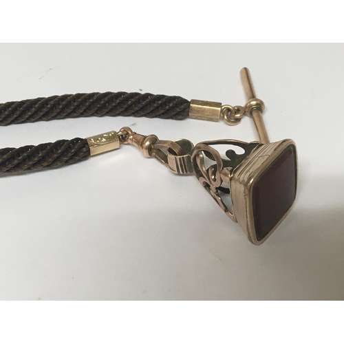 778 - A late Victorian unmarked gold seal attached to a woven hair cord with gold clip and bar.