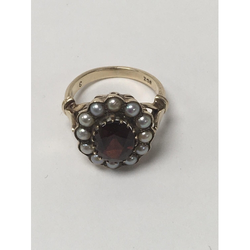 780 - A 9 ct gold Victorian style ring inset with a central garnet surrounded by Pearls size k