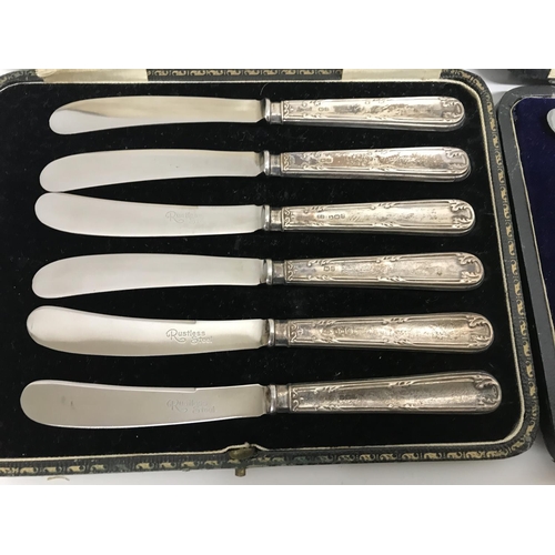 794 - Cased cutlery comprising six silver coffee spoons two cased set of butter knifes with silver handles... 