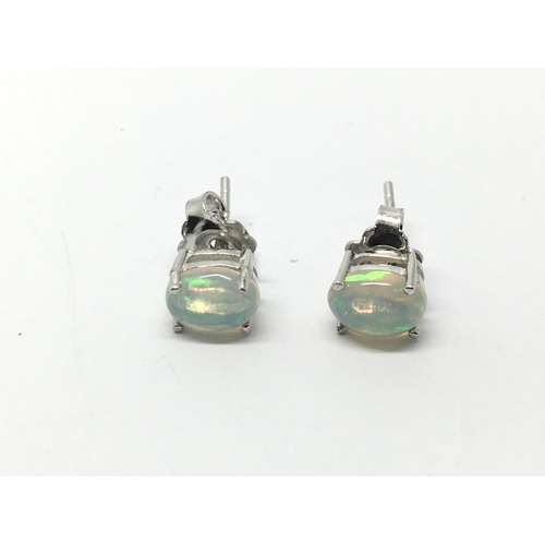 821 - A pair of silver studs set with white Ethiopian opals.