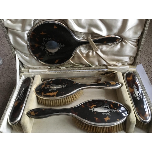 848 - A cased silver and tortoiseshell pique work dressing table set, Sheffield hallmarks.