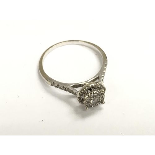 881 - An 18ct white gold (unmarked tested ) illusion set diamond ring. Q.