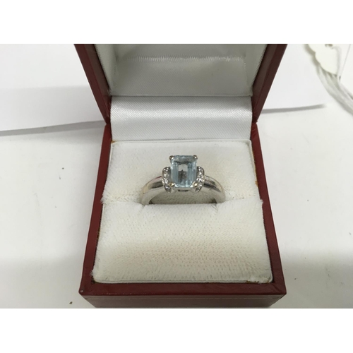 923 - A 18 ct gold ring inset with central aquamarine flanked by diamonds size N .