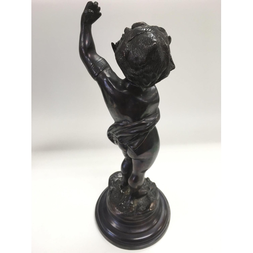 817 - A bronze figure of a putto raised on a stepped circular base, approx height 39cm.