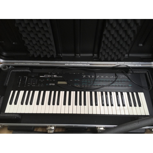 716 - A Yamaha DX11 synthesizer with hard carry case and original retail box.