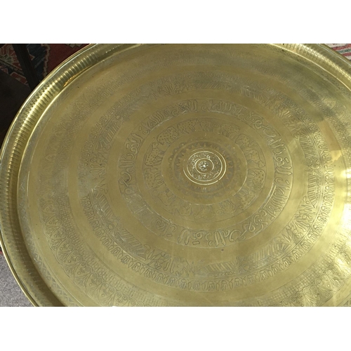 1246 - A brass topped Middle Eastern occasional table with a folding base.